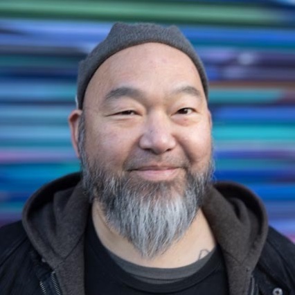 Khan Wong, an Asian man with a hat and a short grey beard.